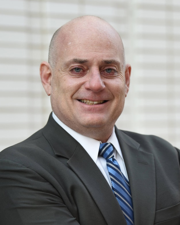 Outdoor headshot of Dan Burns, advisor and lawyer, at Bradley Company offices in Grand Rapids Michigan
