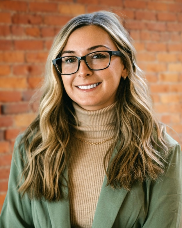 Fort-Wayne based northeastern Indiana commercial property manager, Megan Brown, standing in front of brick wall at 127 Wayne Street.